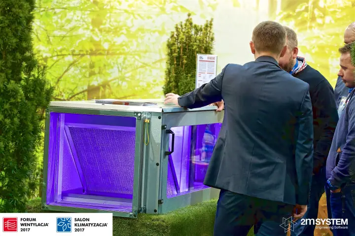 Visitors examine a VBW duct unit lit with violet light at Forum Wentylacja 2017