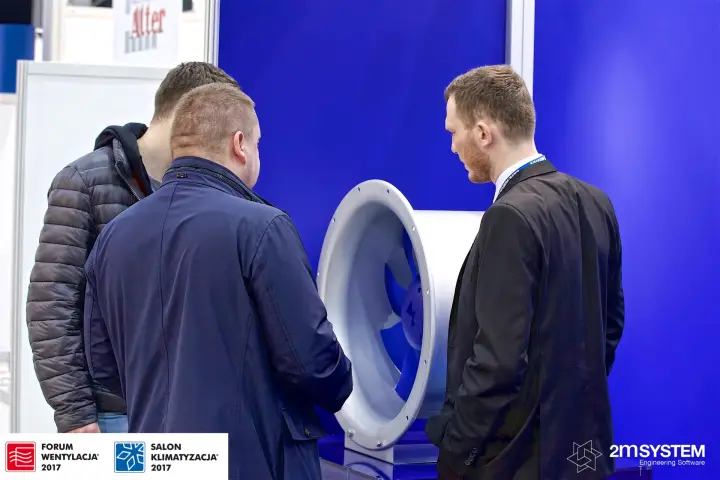 Visitors inspecting an axial fan with blue blades at the Ziehl-Abegg stand