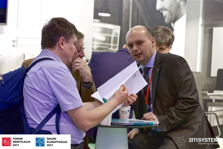 Visitors reviewing a Hitachi catalogue at a meeting table at Forum Wentylacja 2017