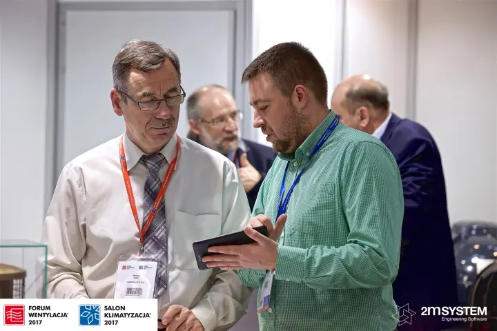 Visitors reviewing a tablet at the Uniwersal stand at Forum Wentylacja 2017