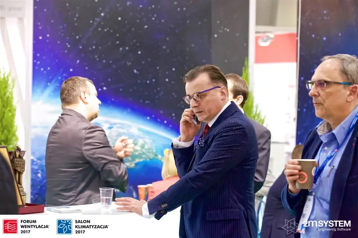 Visitors at a stand with a starry space backdrop and an award trophy
