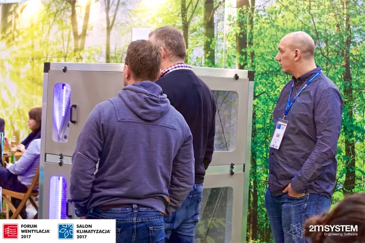 Visitors studying a windowed VBW ventilation unit with LED lighting at Forum Wentylacja 2017