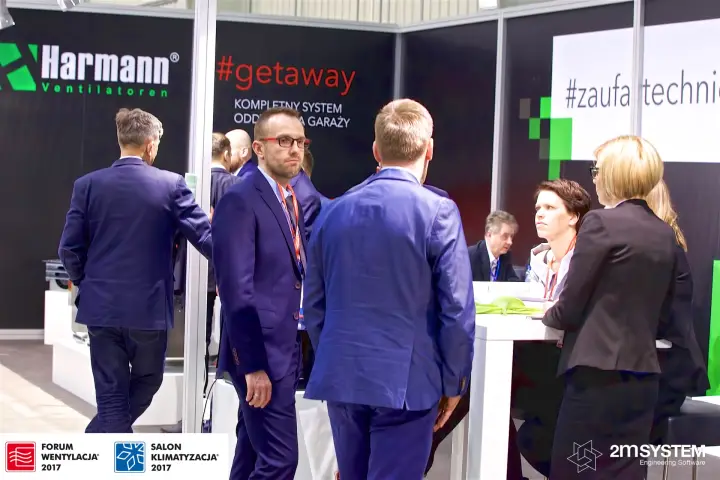 Visitors talking at the Harmann stand beneath the #getaway garage system wall at Forum Wentylacja 2017