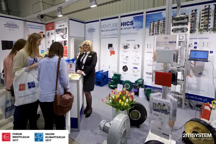 Visitors at the Venture Industries counter beside the HICS product display