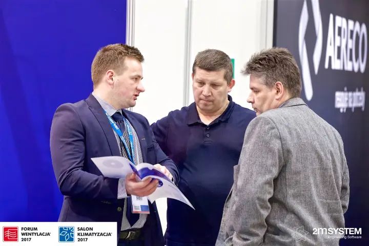 Ziehl-Abegg staff member presenting a brochure to visitors at Forum Wentylacja 2017