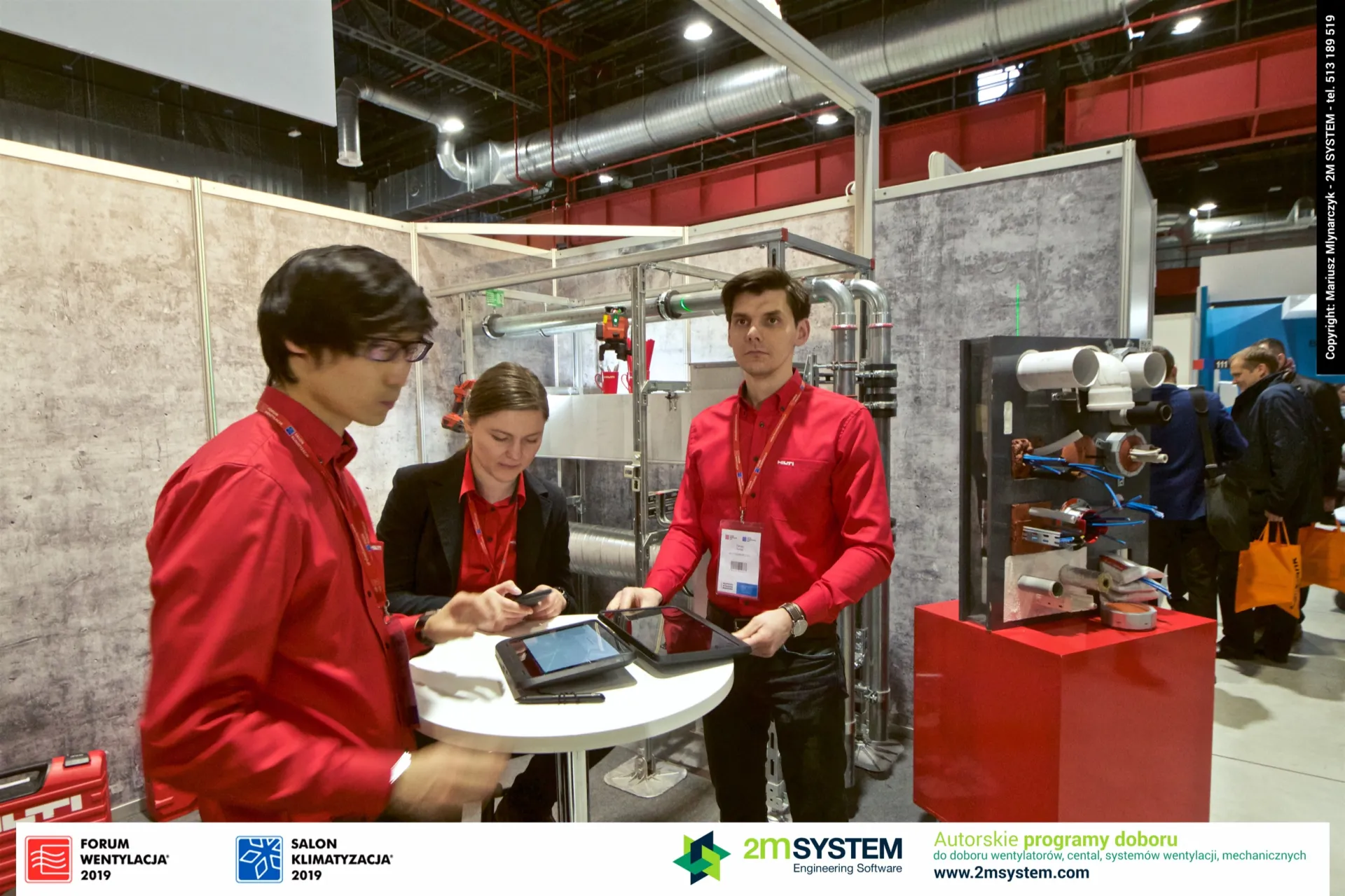 Hilti staff at a tablet table in front of a pipe support frame at Forum Wentylacja 2019
