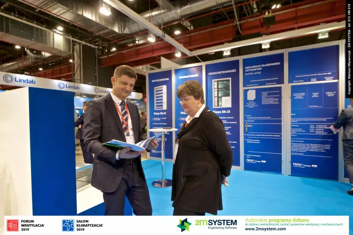 Leafing through product literature in front of the Trox information wall at Forum Wentylacja 2019