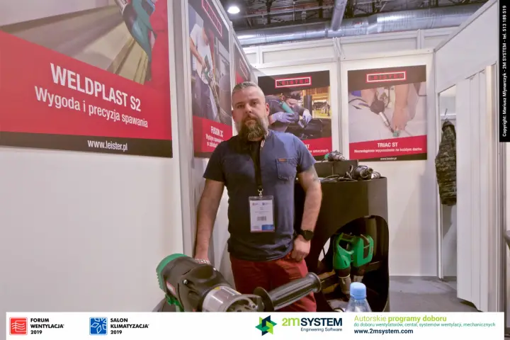 Leister staff with a hand extruder in front of the Weldplast S2 poster at Forum Wentylacja 2019