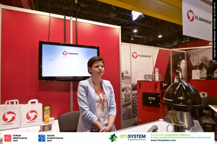 Staff member at the Klimawent counter with company screen behind
