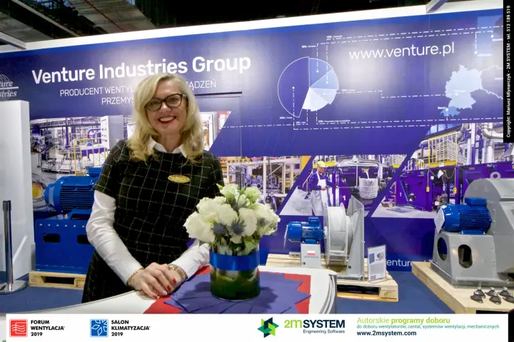 Venture Industries Group staff at the counter in front of industrial fans at Forum Wentylacja 2019