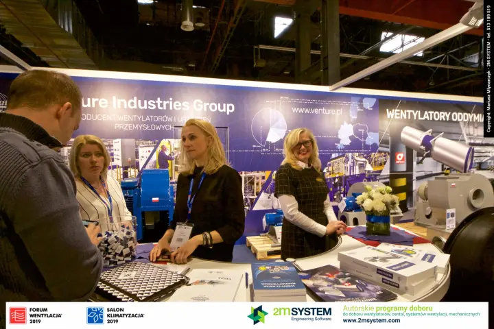 Visitor talks with Venture Industries team over brochures at the counter at Forum Wentylacja 2019