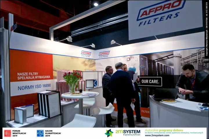 Visitors in discussion at the AFPRO Filters stand beside filter samples