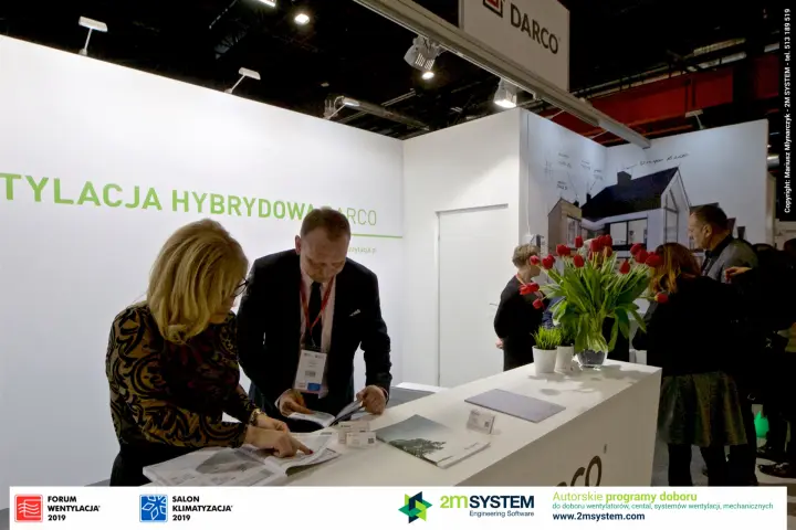 Visitors reading catalogues at the Darco counter with red tulips at Forum Wentylacja 2019