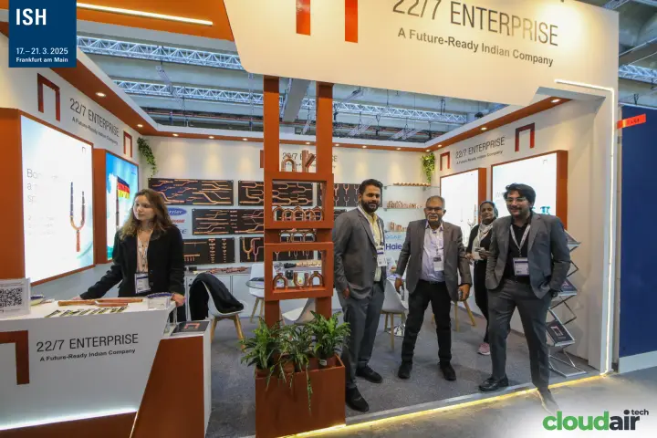 22/7 Enterprise team posing in front of copper branch joint displays