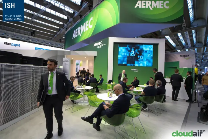 Aermec lounge under a suspended green banner, with an outdoor unit alongside at ISH 2025