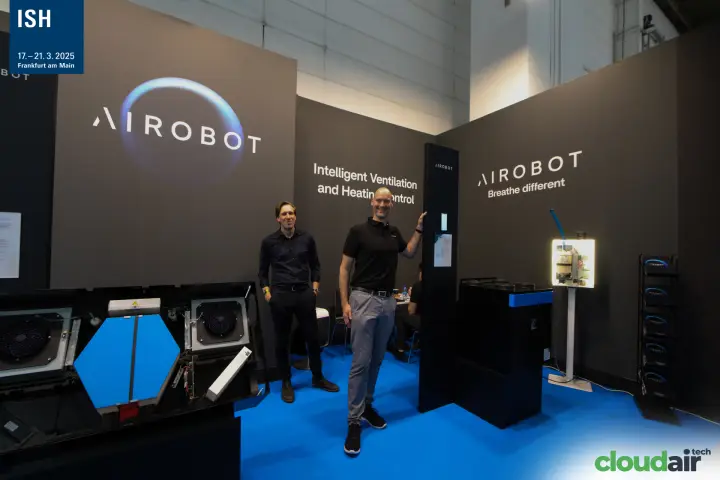Airobot team beside an open heat recovery unit with blue exchanger at ISH 2025