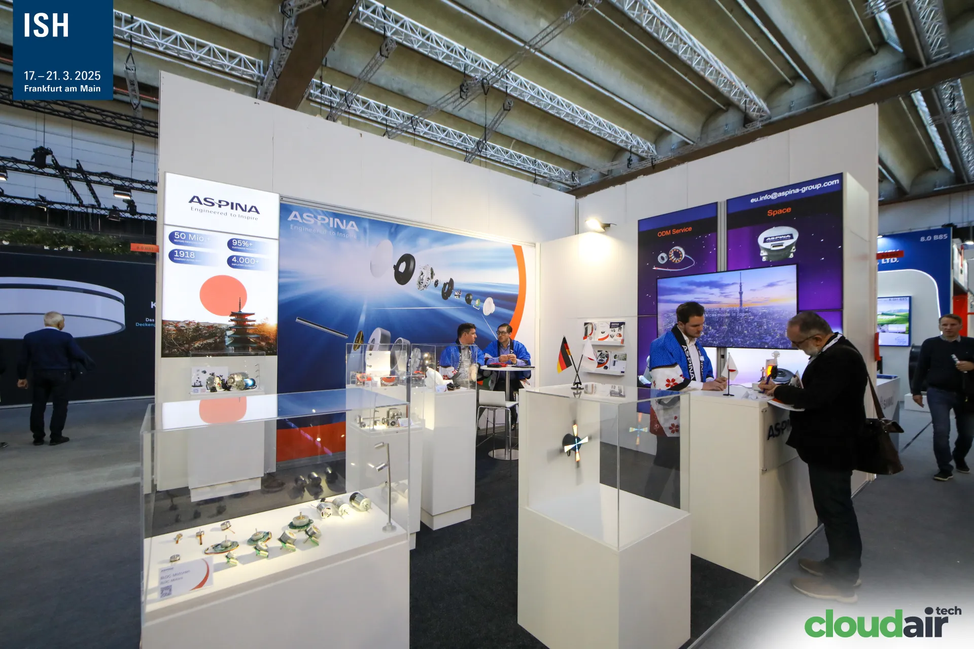 Aspina stand with small motors in glass display cases at ISH 2025