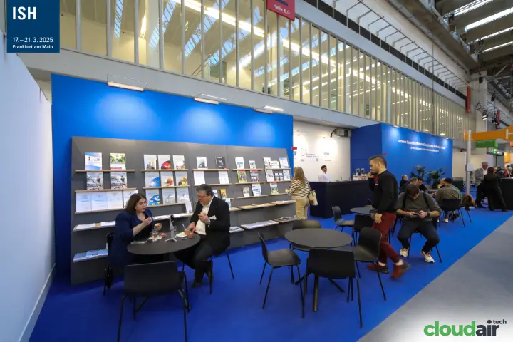 Association lounge with publication shelves on a blue stand in Hall 8.0