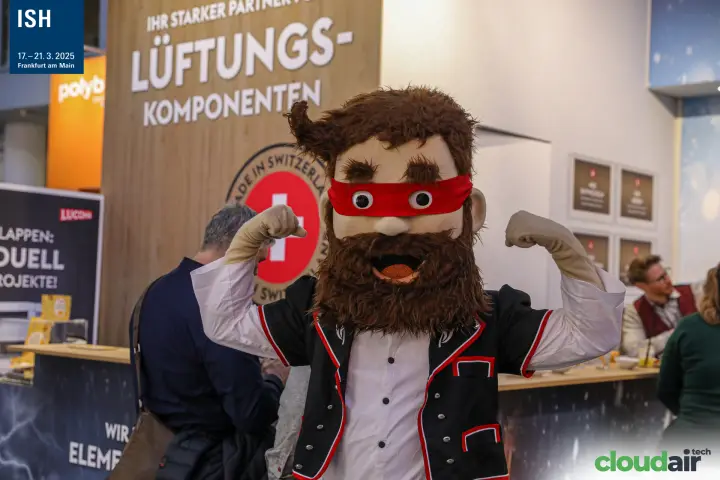Close-up of the Swiss mascot posing at the Lucoma stand at ISH 2025