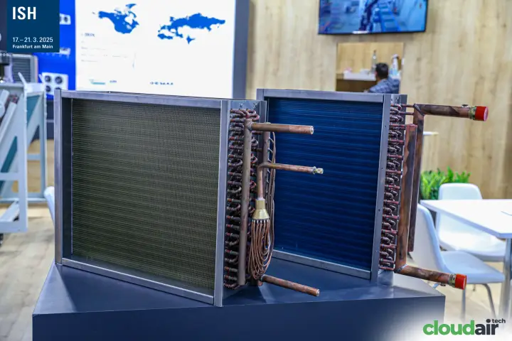 Copper-tube finned coils with distributor on a dark display plinth at ISH 2025