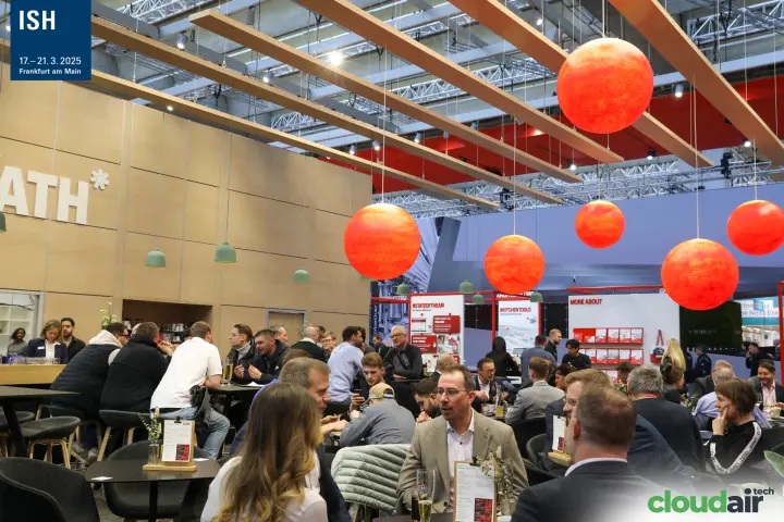 Crowded café lounge with orange globe lamps near the robatherm stand at ISH 2025