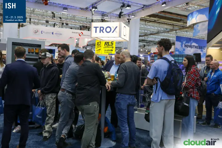 Crowded TROX stand with bar tables under the illuminated logo at ISH 2025