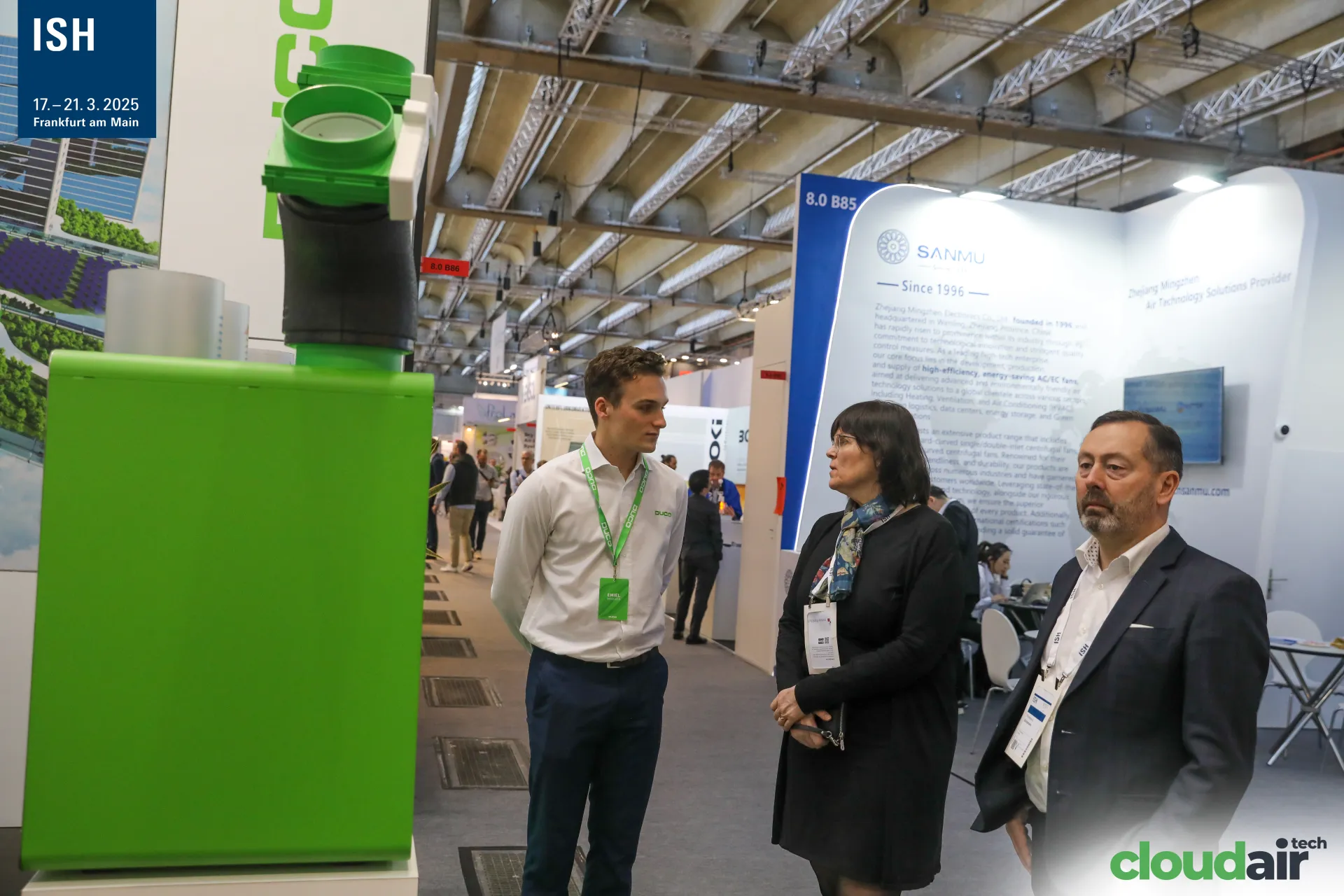 Duco staff talking with visitors next to a green DucoBox unit at ISH 2025