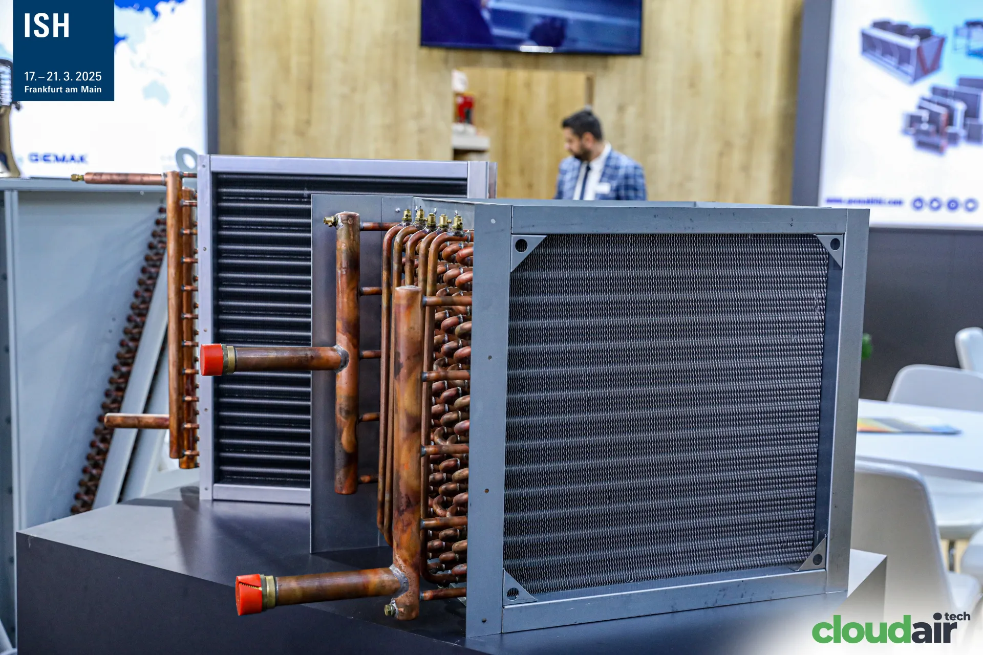 Gemak finned copper-tube coils with red-capped headers on a display plinth at ISH 2025