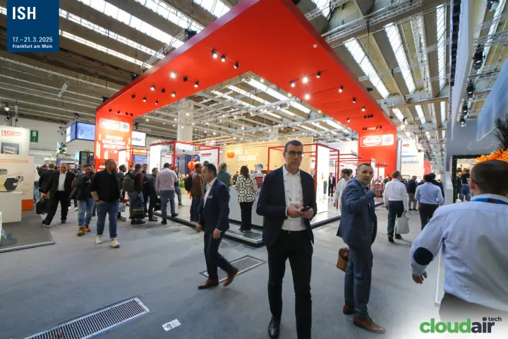 Helios stand framed by a large red canopy above a busy aisle at ISH 2025
