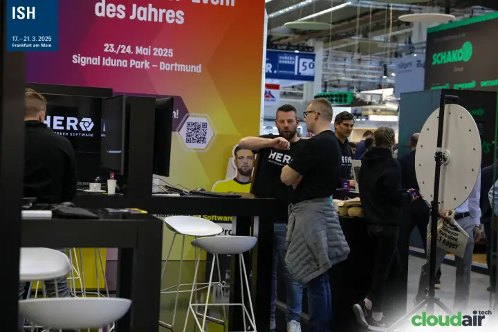 HERO stand counter with screens and event poster at ISH 2025
