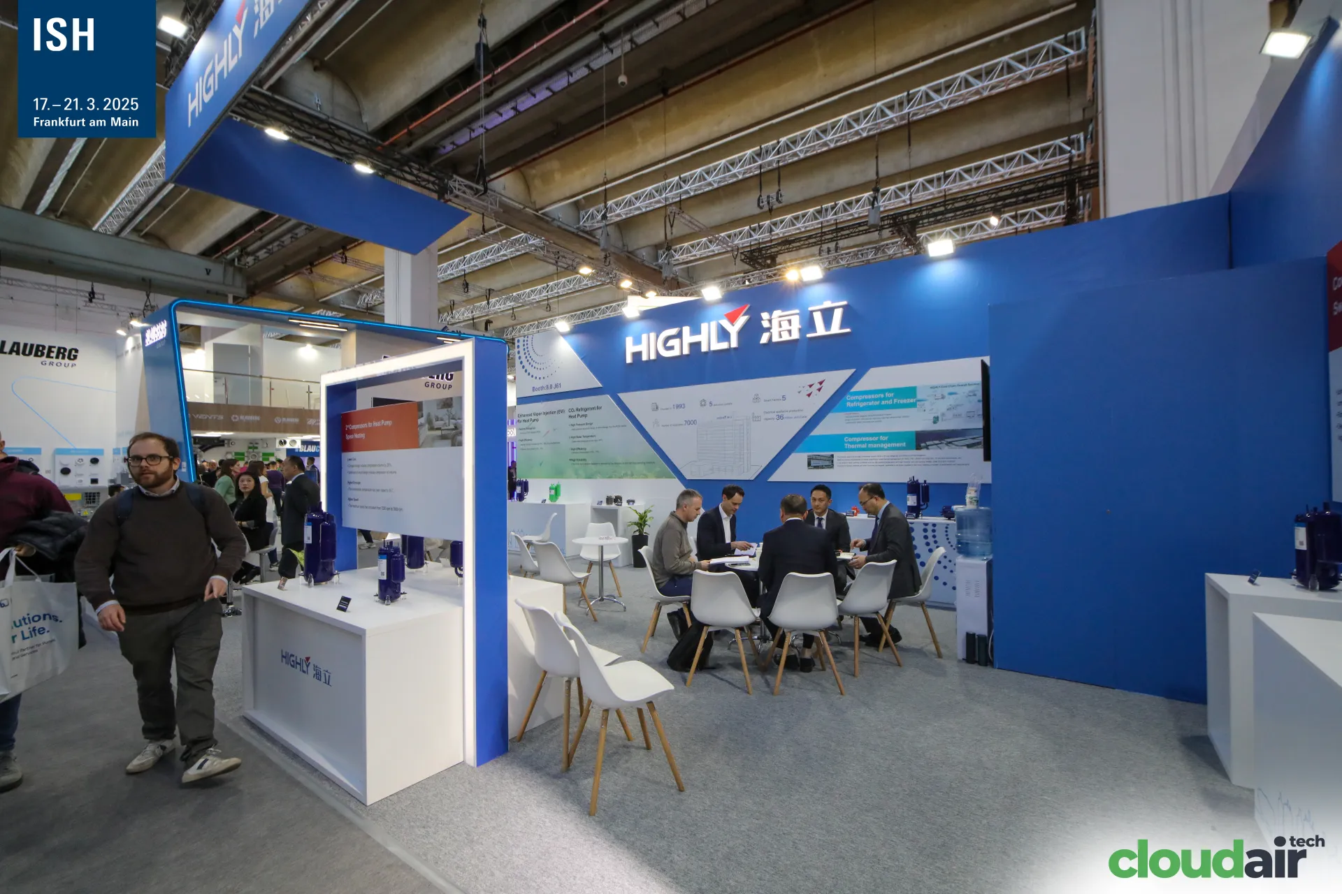 Highly compressor stand with meeting tables and blue wall graphics at ISH 2025