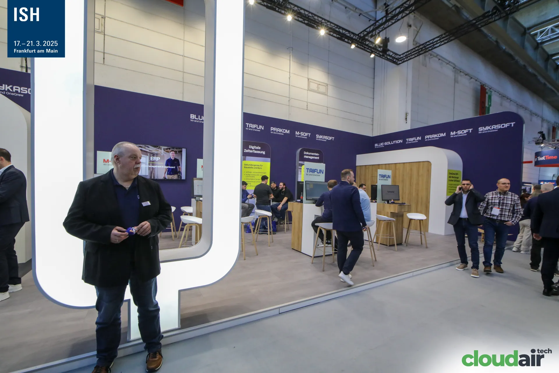 Illuminated OneQrew Q frames the software stand with brand demo desks at ISH 2025