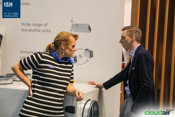 Komfovent staff beside a low-profile heat recovery unit