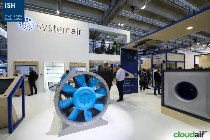 Large axial fan with blue impeller in front of the illuminated Systemair logo at ISH 2025