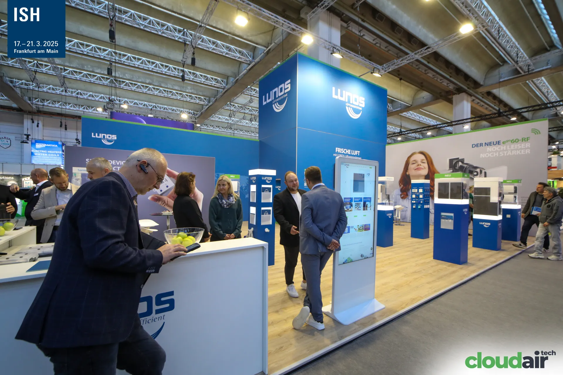Lunos reception counter and touchscreen kiosk beside the product showcases at ISH 2025