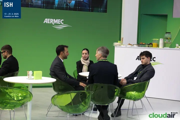 Meeting tables in front of the green Aermec wall and catering counter at ISH 2025