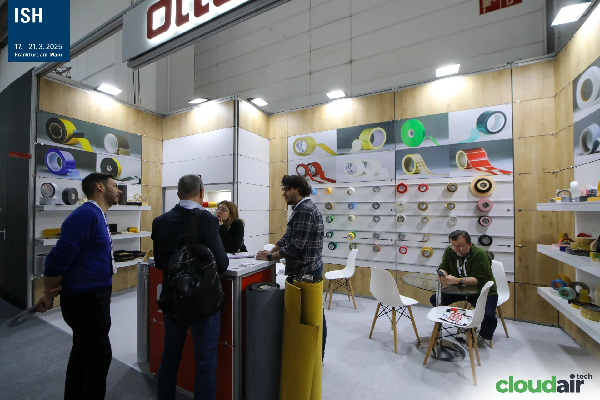 Otte adhesive tape display wall with visitors at the red counter at ISH 2025
