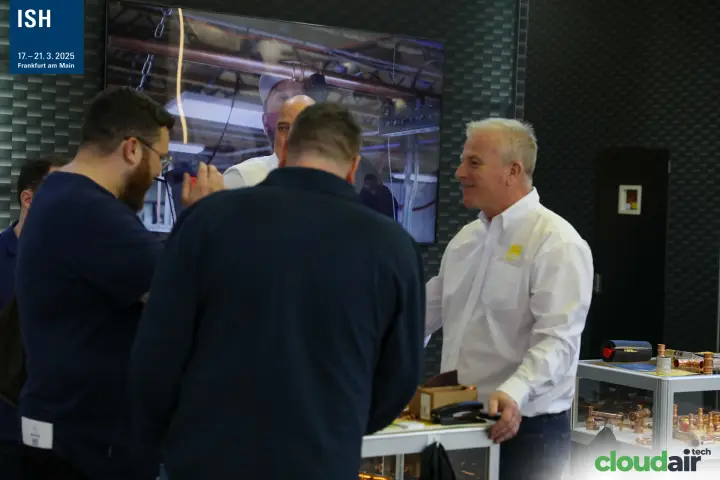 RLS staff with visitors beside a showcase of copper press fittings