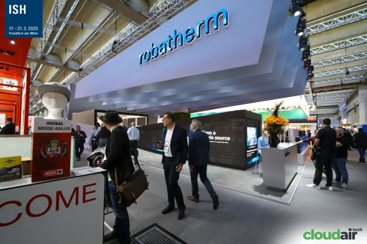 Robatherm illuminated logo above its stand, seen past a Helios welcome desk at ISH 2025