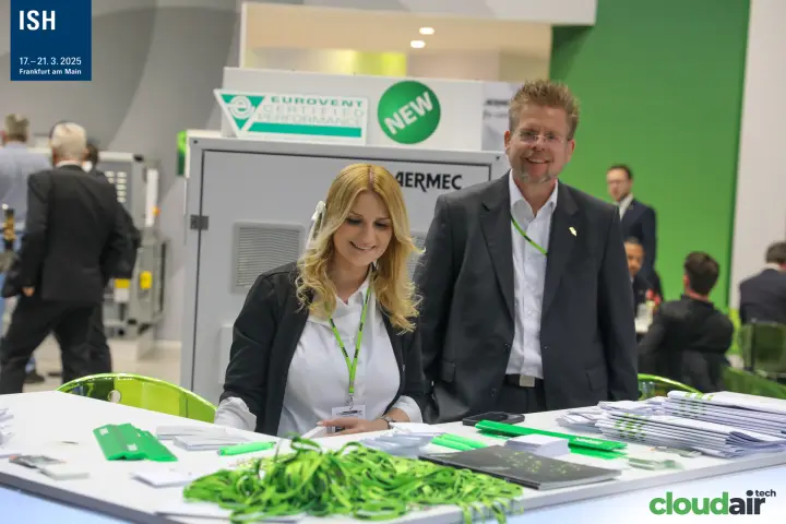 Smiling Aermec team at the welcome desk in front of a new unit at ISH 2025