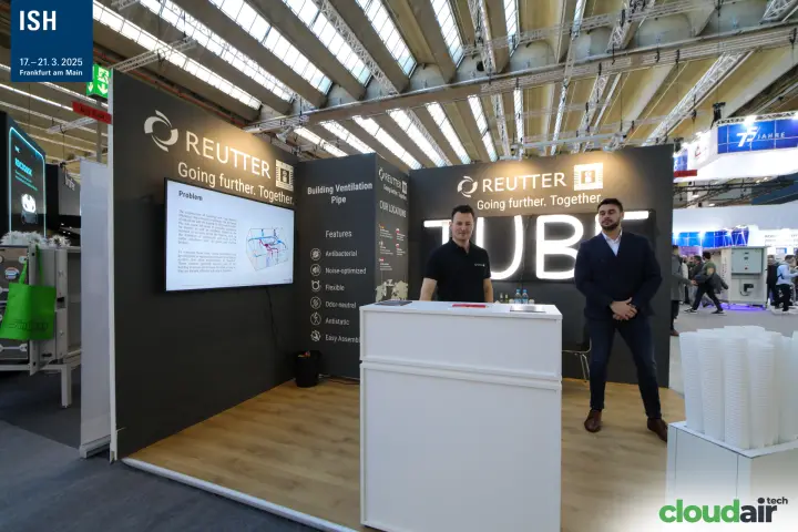 Staff at the Reutter counter in front of the lit "TUBE" sign at ISH 2025