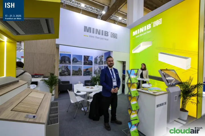 Staff welcoming visitors at the Minib stand beside trench convector displays