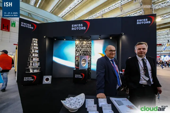 Swiss Rotors staff beside a plug fan on a branded plinth