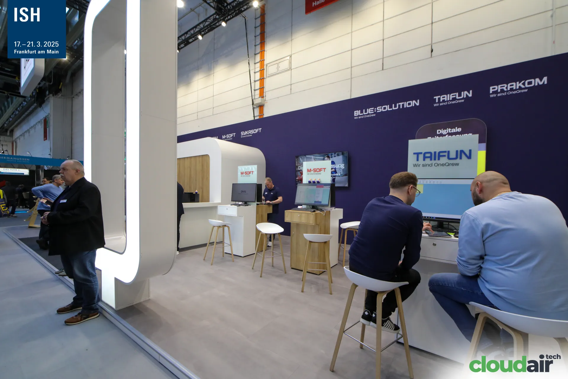 Taifun and M-Soft workstations along the purple OneQrew wall at ISH 2025