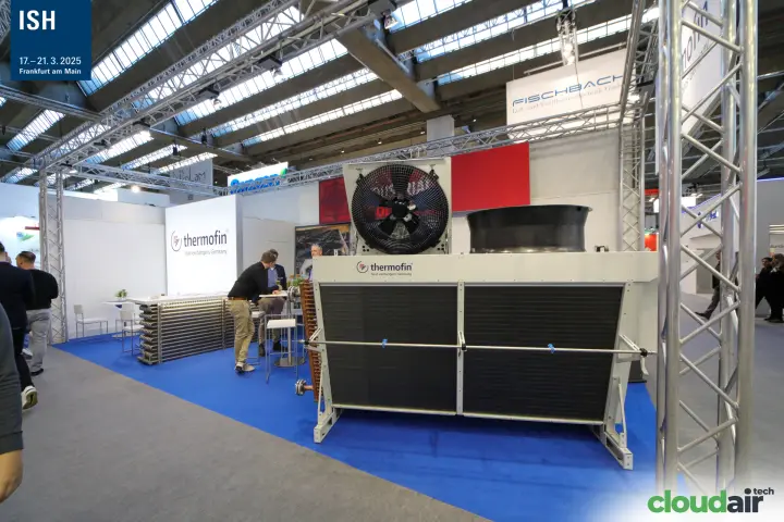 Thermofin heat exchanger unit with axial fan and finned coils on a blue-carpeted stand at ISH 2025