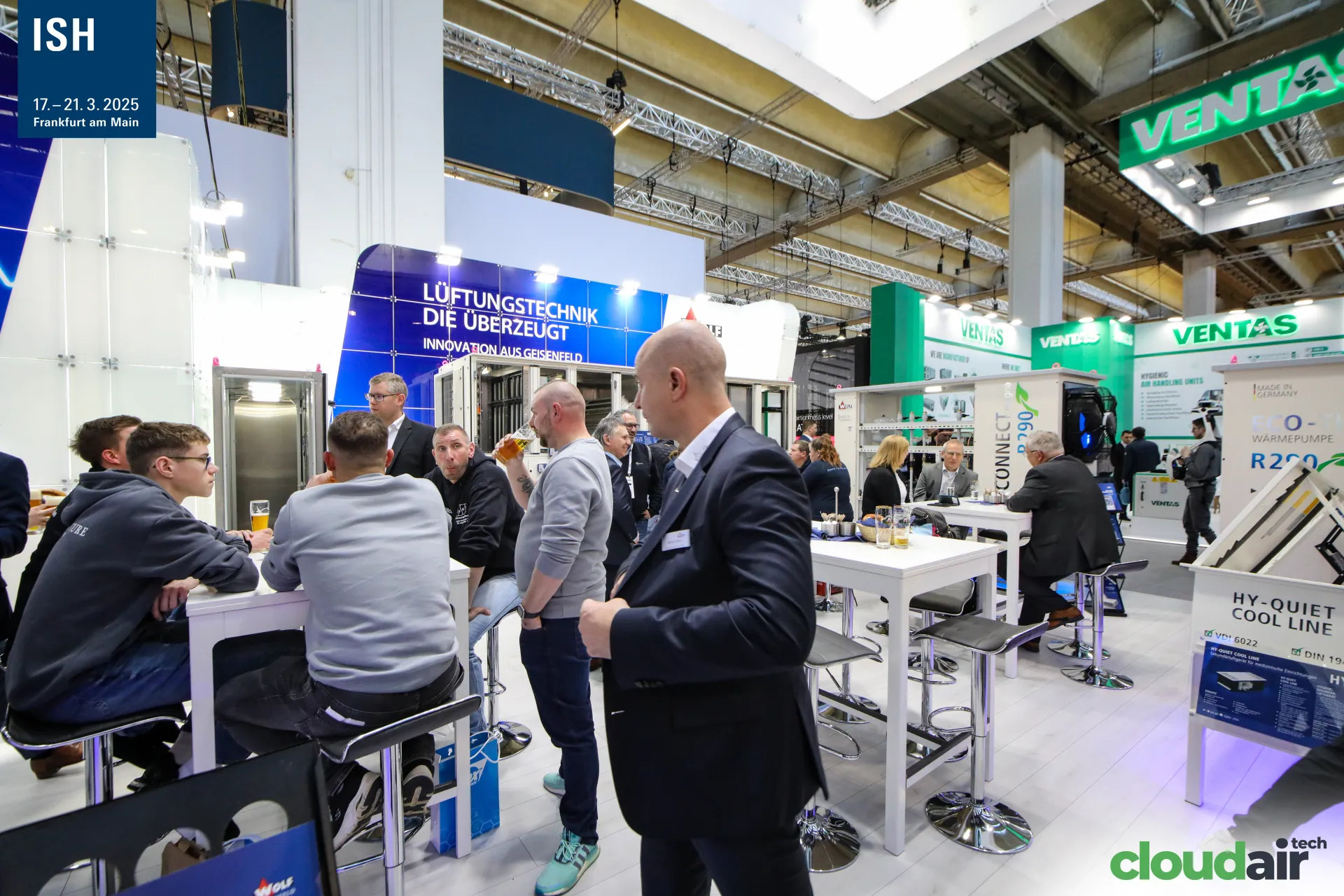 Visitors with drinks at bar tables in the Wolf Geisenfeld meeting area at ISH 2025