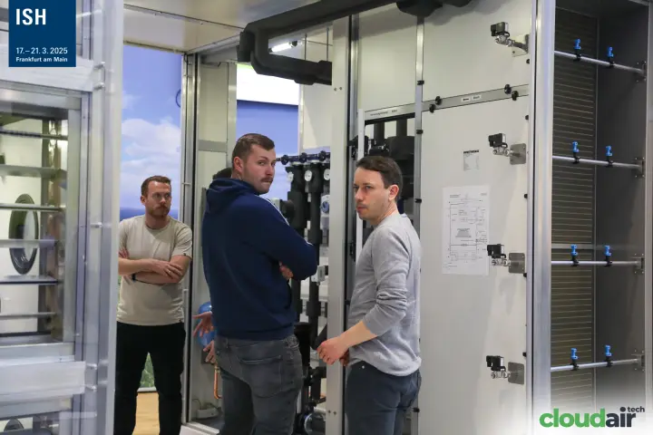 Visitors inside a Howatherm AHU with hydronic piping and valves