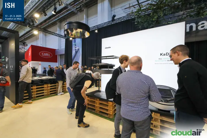 Visitors inspect the KaDius ceiling unit on the Kampmann stand at ISH 2025