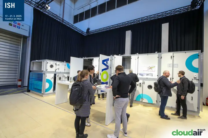 Visitors inspect open NOVA air handling units at a high table at ISH 2025