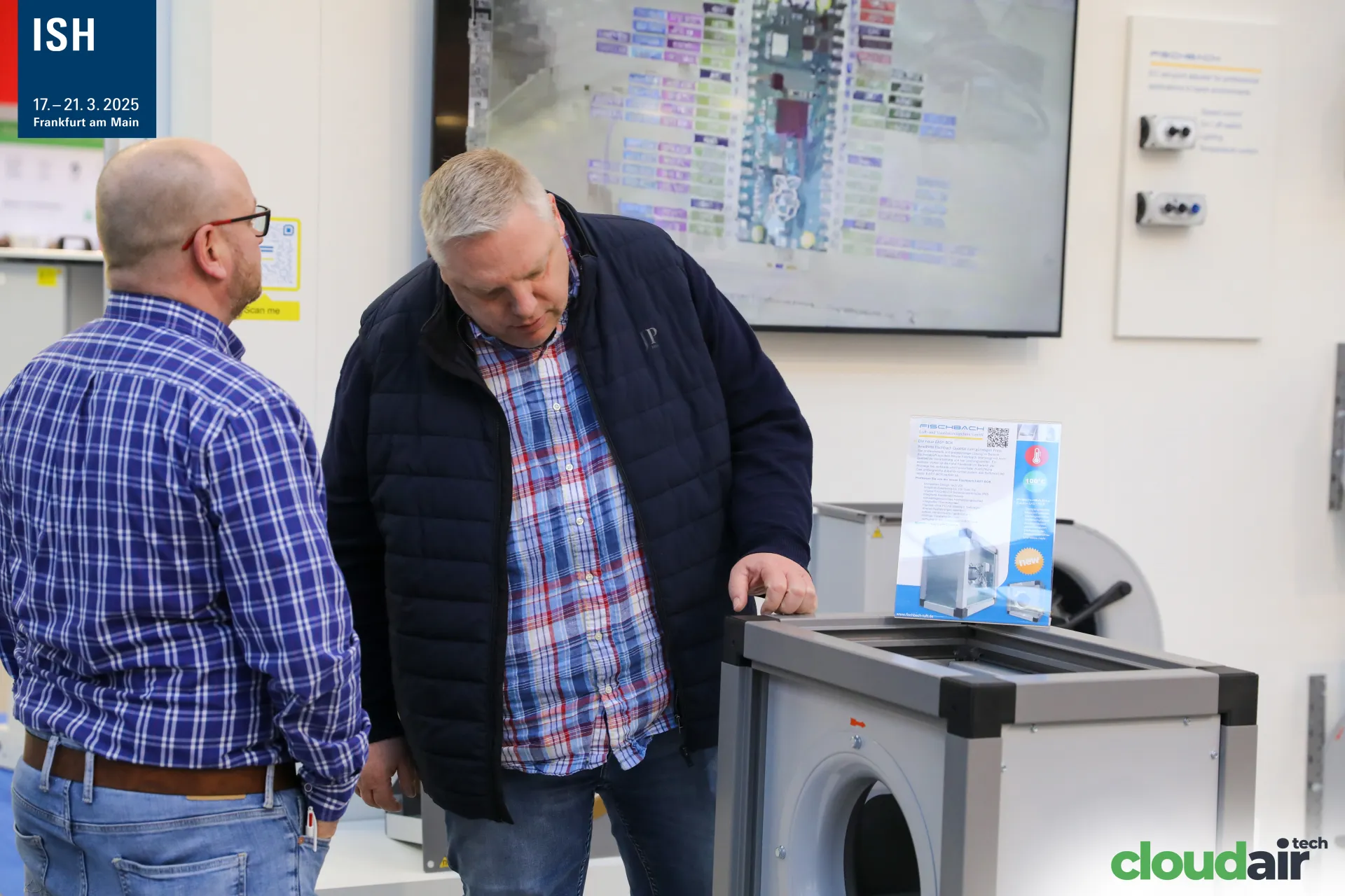 Visitors inspecting a Fischbach box fan marked as new at ISH 2025